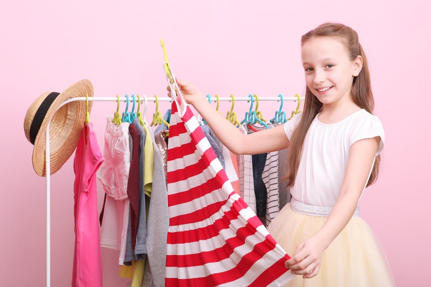 cute-cheerful-little-girl-chooses-clothes-with-floor-hangers